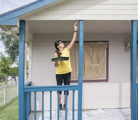 A picture of a person painting a house