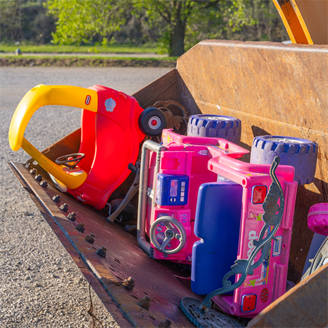 Bulky items awaiting disposal in a front loader's bucket